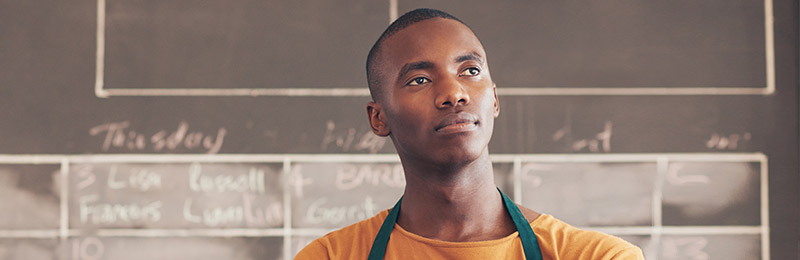 Male entrepreneur looking out into the distance considering the future and deciding if he needs a long-term plan.